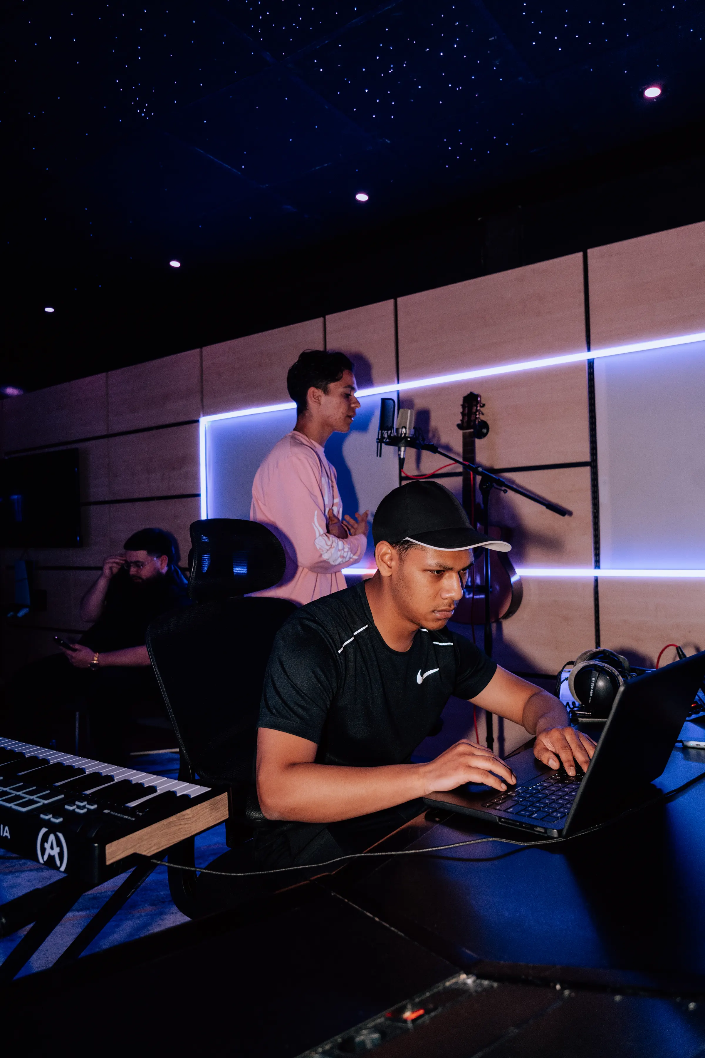 Drie mensen samen aan het werk in de studio